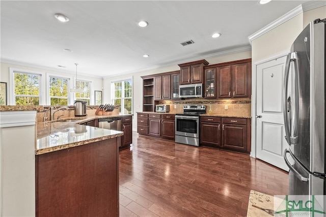 kitchen featuring dark wood finished floors, tasteful backsplash, visible vents, appliances with stainless steel finishes, and a sink