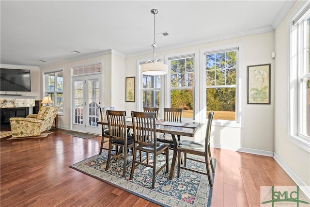 dining area with plenty of natural light, wood finished floors, and crown molding