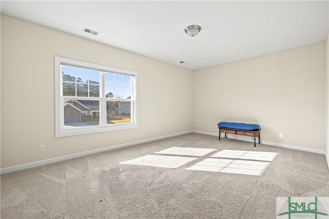 carpeted empty room with visible vents and baseboards