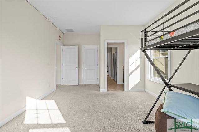 unfurnished bedroom with carpet, visible vents, and baseboards