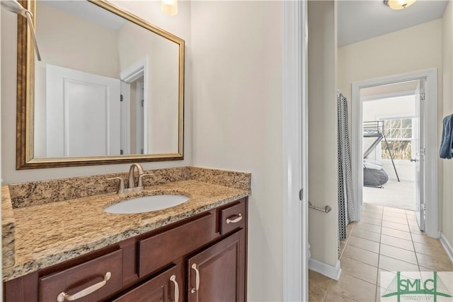 full bath with tile patterned flooring, vanity, and baseboards