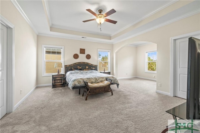 carpeted bedroom with arched walkways, ornamental molding, and baseboards