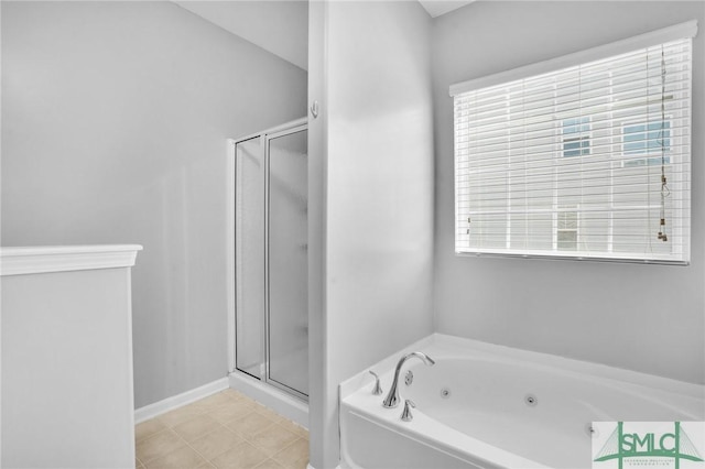 bathroom with a stall shower, baseboards, a tub with jets, and tile patterned floors