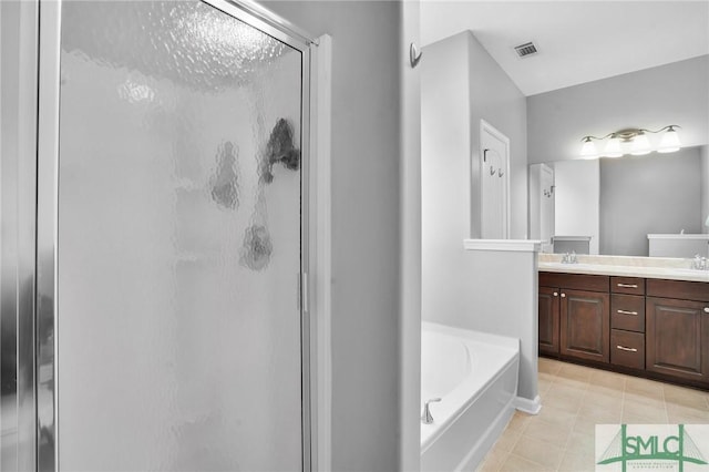 bathroom featuring a garden tub, a sink, tile patterned floors, double vanity, and a stall shower