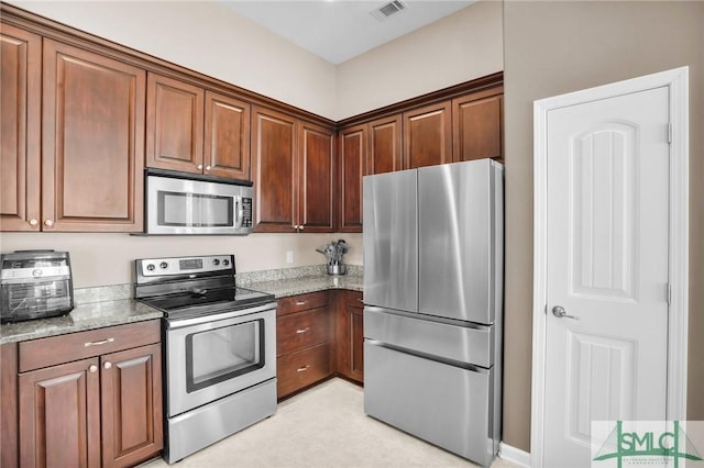 kitchen with light stone countertops, visible vents, and appliances with stainless steel finishes