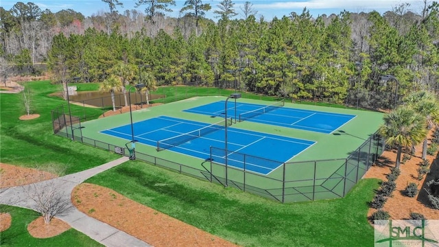 view of sport court featuring fence and a lawn