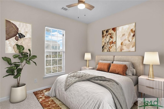 carpeted bedroom with a ceiling fan, multiple windows, visible vents, and baseboards