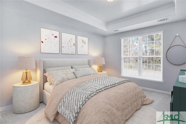 bedroom with a tray ceiling, multiple windows, visible vents, and baseboards