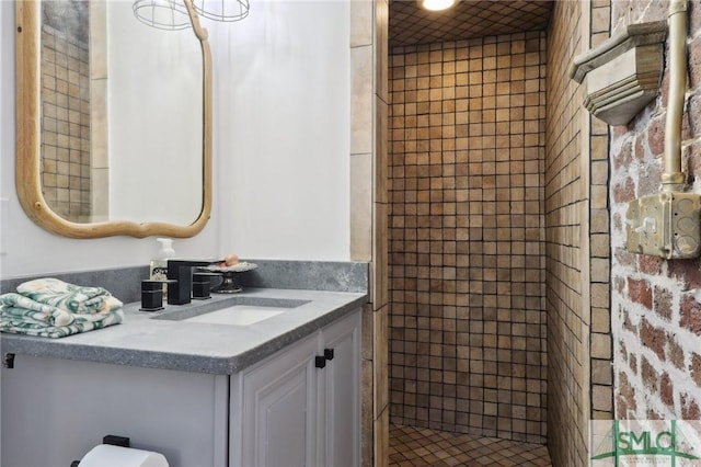 bathroom featuring tiled shower and vanity