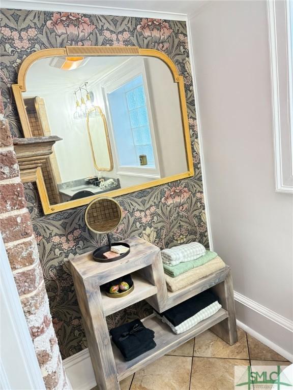 bathroom with baseboards, tile patterned floors, and wallpapered walls