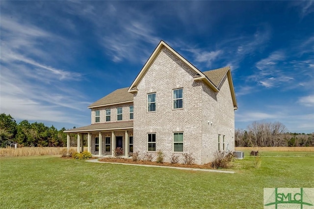 back of property featuring brick siding, a lawn, and central air condition unit