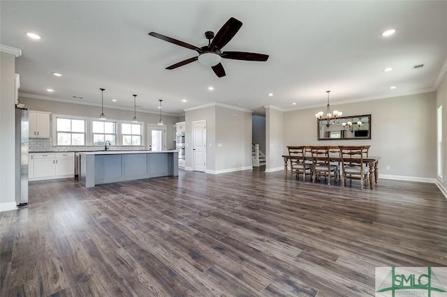 kitchen featuring white cabinetry, open floor plan, freestanding refrigerator, dark wood-style floors, and a center island with sink