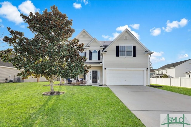 traditional home with an attached garage, solar panels, fence, driveway, and a front lawn