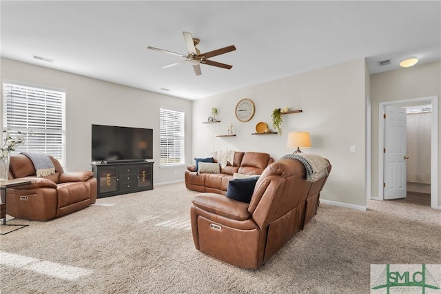 carpeted living area featuring a ceiling fan, visible vents, and baseboards