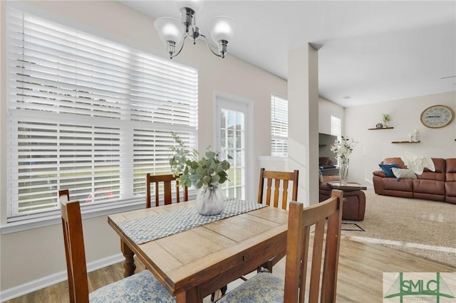 dining room with a notable chandelier, baseboards, and wood finished floors