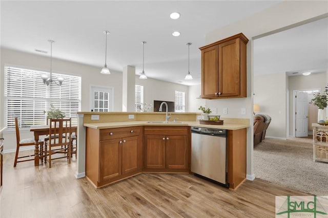 kitchen featuring dishwasher, brown cabinets, a peninsula, light countertops, and a sink