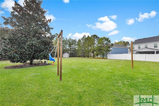 view of yard with a playground, a storage unit, an outdoor structure, and fence