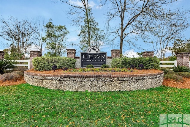 community / neighborhood sign featuring fence and a yard