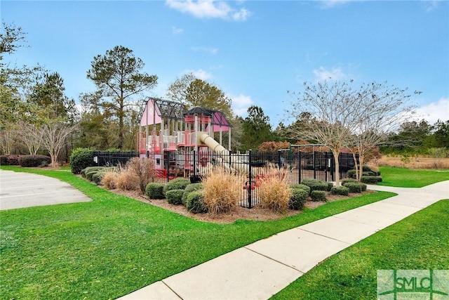 communal playground featuring a lawn and fence