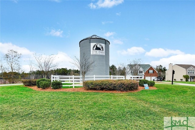 view of property's community featuring a yard and fence