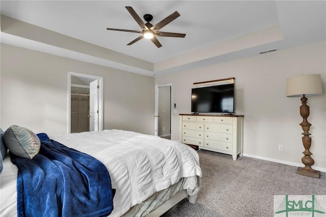 carpeted bedroom with visible vents, a tray ceiling, ceiling fan, and baseboards