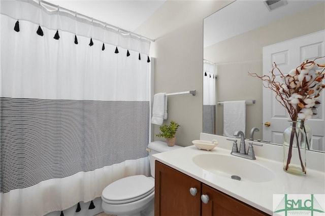 bathroom featuring toilet, a shower with shower curtain, vanity, and visible vents