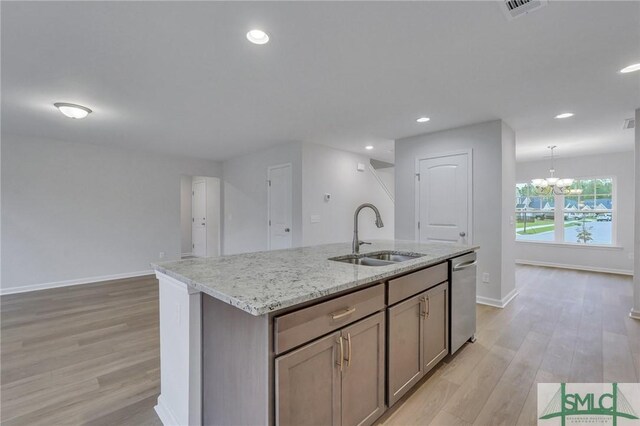 176 Orkney Rd, Savannah, GA 31407 - kitchen with a kitchen island with sink, stainless steel dishwasher, a sink, and light wood-style flooring