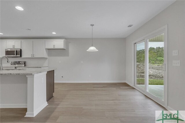 176 Orkney Rd, Savannah, GA 31407 - kitchen featuring light wood-style floors, appliances with stainless steel finishes, white cabinets, and light stone counters