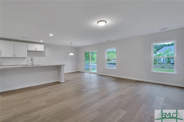 176 Orkney Rd, Savannah, GA 31407 - unfurnished living room with recessed lighting, a sink, visible vents, baseboards, and light wood-type flooring