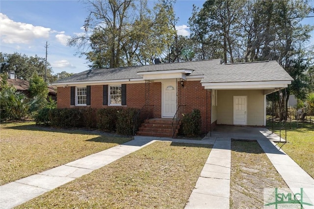 single story home featuring brick siding, roof with shingles, and a front yard