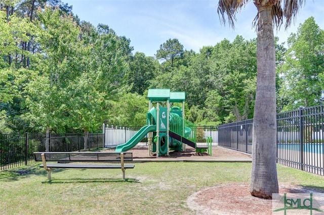 community jungle gym with fence and a lawn