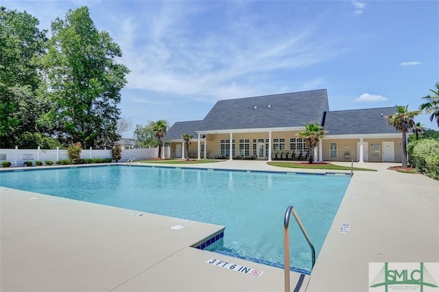 community pool with fence and a patio