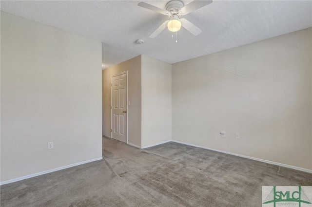carpeted empty room with a textured ceiling, a ceiling fan, and baseboards