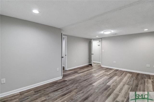 finished below grade area with recessed lighting, baseboards, and wood finished floors