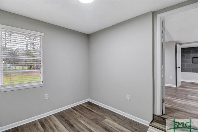 unfurnished room with baseboards and wood finished floors