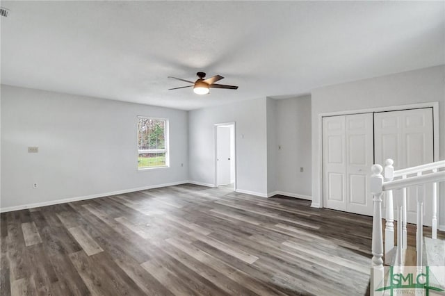 unfurnished bedroom with ceiling fan, visible vents, baseboards, a closet, and dark wood finished floors