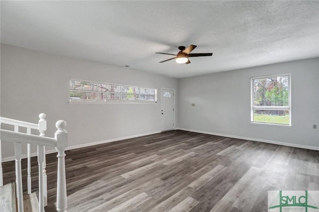 spare room featuring ceiling fan, a textured ceiling, baseboards, and wood finished floors