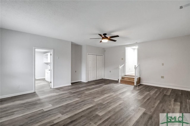 unfurnished bedroom with ceiling fan, a closet, baseboards, and dark wood-style flooring