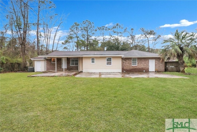 back of house with a yard, brick siding, a patio, and fence