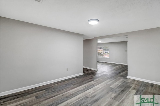 spare room with wood finished floors and baseboards