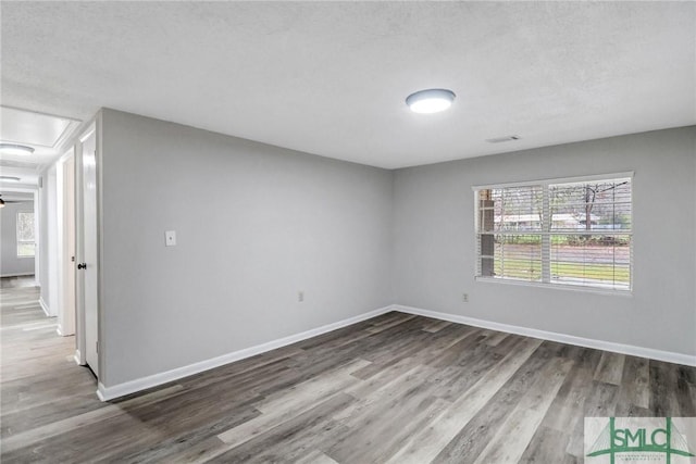 unfurnished room with baseboards and wood finished floors