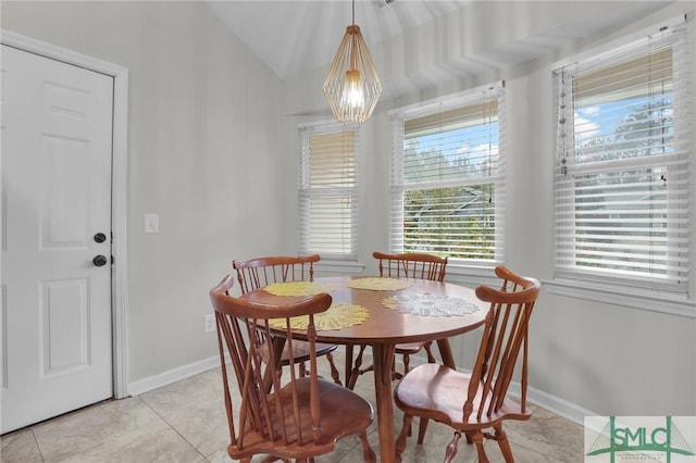 dining room with a notable chandelier, vaulted ceiling, baseboards, and light tile patterned floors