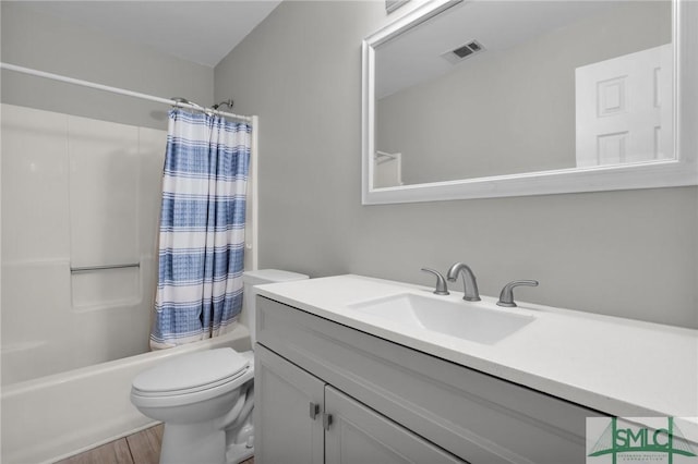 bathroom with toilet, wood finished floors, vanity, visible vents, and shower / bathtub combination with curtain