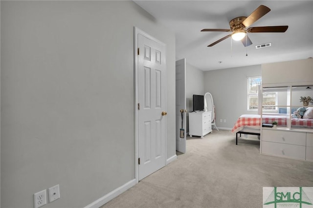 bedroom with a ceiling fan, light colored carpet, visible vents, and baseboards