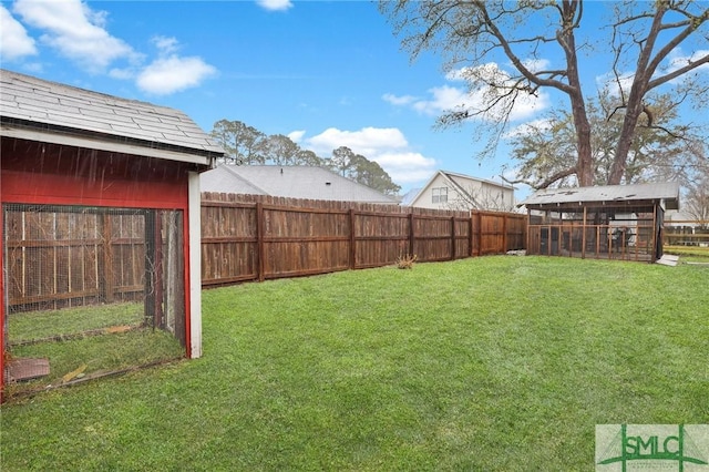 view of yard featuring a fenced backyard and an outbuilding