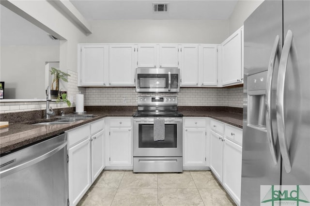 kitchen featuring stainless steel appliances, a sink, visible vents, white cabinets, and tasteful backsplash