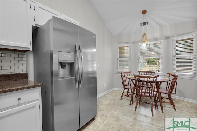 kitchen with decorative backsplash, a wealth of natural light, vaulted ceiling, and stainless steel fridge with ice dispenser