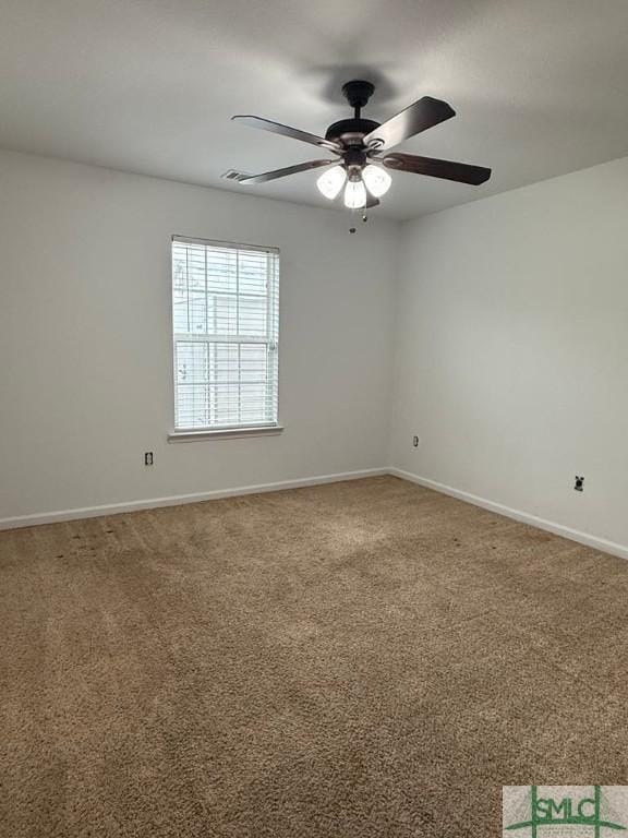 empty room with carpet floors, a ceiling fan, and baseboards