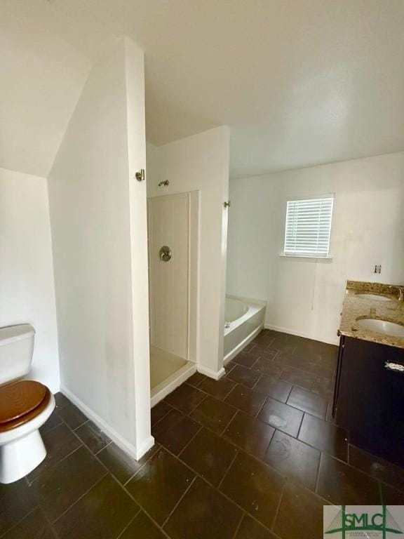 bathroom featuring a garden tub, toilet, a stall shower, vanity, and baseboards