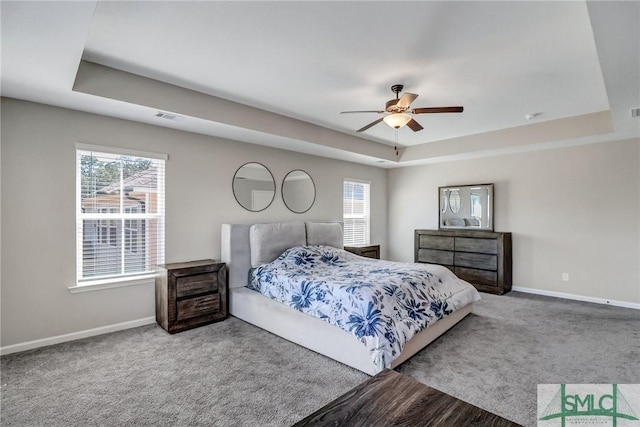 bedroom with carpet, baseboards, visible vents, and a tray ceiling